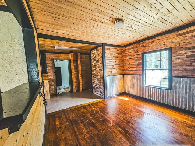 unfurnished room featuring hardwood / wood-style floors, wooden walls, and wooden ceiling