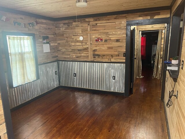 spare room with wood walls and dark hardwood / wood-style flooring