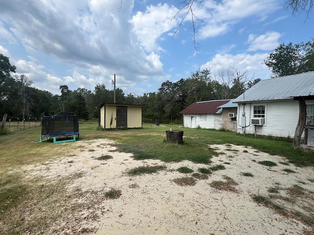 1026 Berry Rd, Lufkin, TX 75904 - view of green lawn with a trampoline, a shed, and cooling unit
