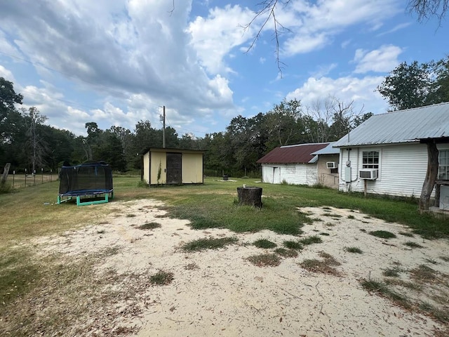 view of yard with a trampoline, a shed, and cooling unit