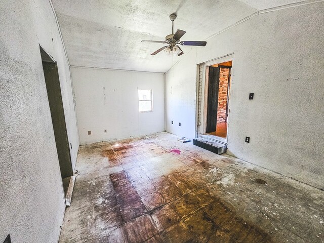 empty room featuring ceiling fan and lofted ceiling