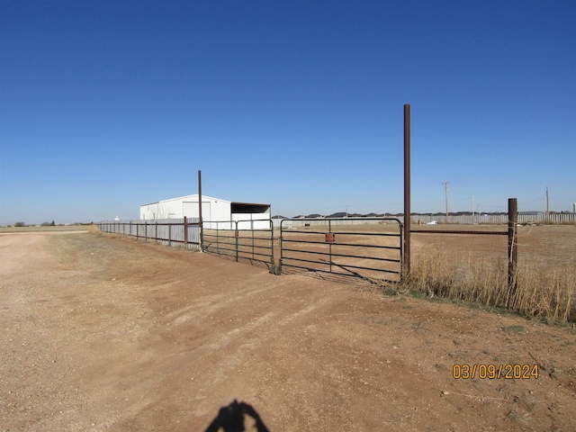 view of yard featuring a rural view and an outdoor structure