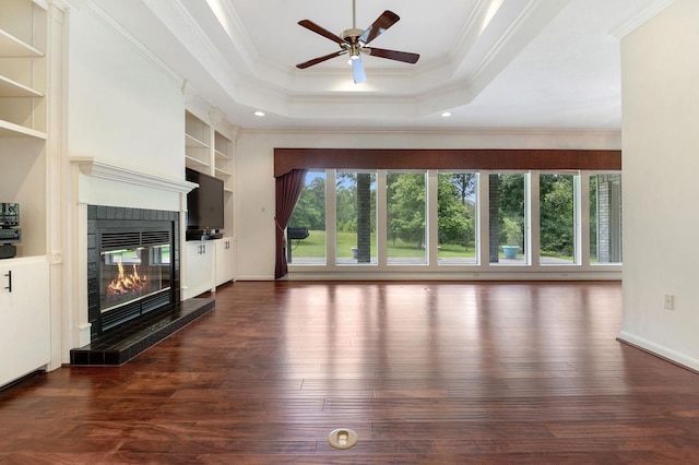 unfurnished living room with built in features, a fireplace, crown molding, and dark hardwood / wood-style floors