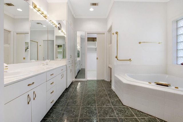 bathroom featuring tiled tub, crown molding, and vanity