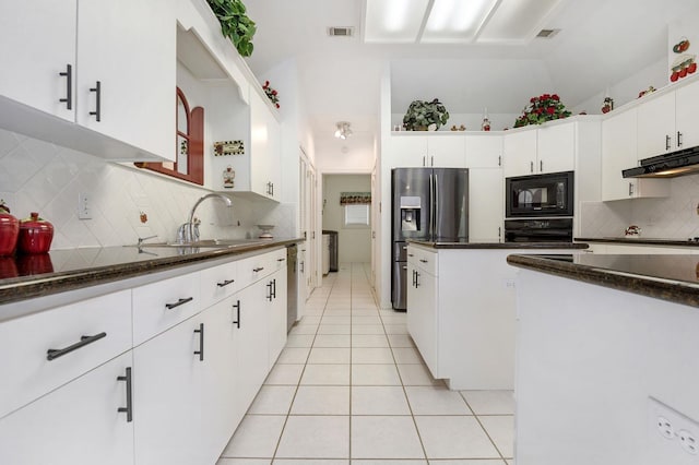 kitchen featuring backsplash, black appliances, dark stone countertops, light tile patterned flooring, and white cabinetry