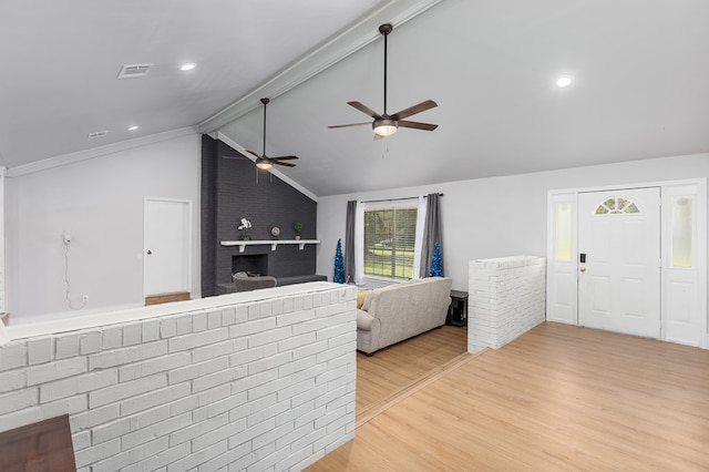 living room featuring vaulted ceiling with beams and light hardwood / wood-style flooring