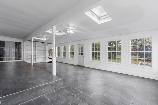 unfurnished sunroom featuring a skylight and ceiling fan