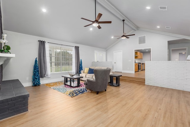 living room featuring beamed ceiling, light wood-type flooring, high vaulted ceiling, and a brick fireplace