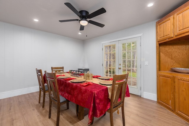 dining room with wood walls, french doors, ceiling fan, light wood-type flooring, and ornamental molding