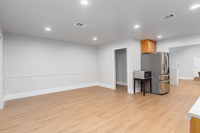 kitchen with stainless steel fridge and light hardwood / wood-style floors