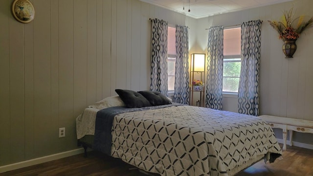 bedroom with wooden walls, dark hardwood / wood-style floors, and ornamental molding