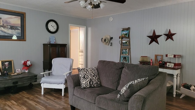 living room with dark hardwood / wood-style floors, ceiling fan, ornamental molding, and wood walls