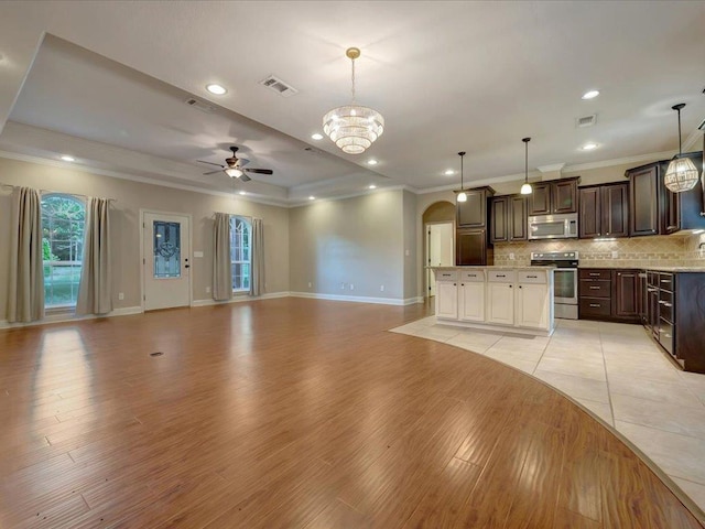 1207 Old Ewing Rd, Lufkin, TX 75901 - kitchen with appliances with stainless steel finishes, open floor plan, arched walkways, crown molding, and a ceiling fan