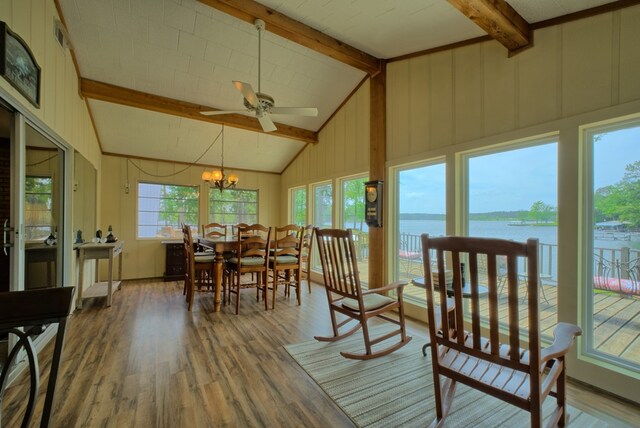 sunroom with a chandelier, beam ceiling, and a water view