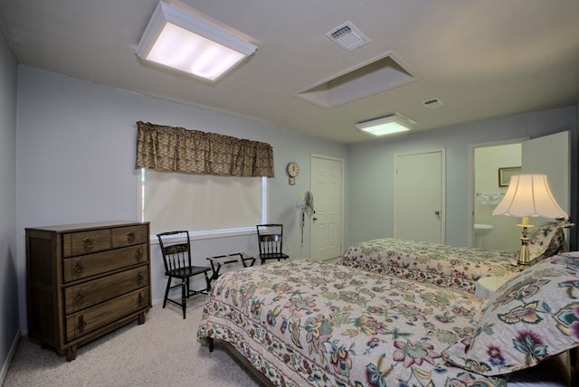 carpeted bedroom featuring ensuite bath and visible vents