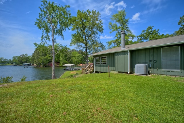 view of yard with a water view and central AC unit