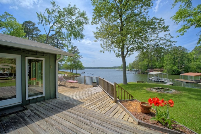 deck with a yard and a water view