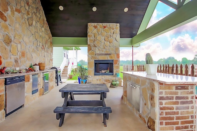 view of patio / terrace with an outdoor stone fireplace, grilling area, and exterior kitchen