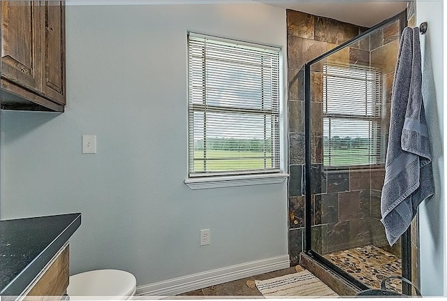 bathroom featuring toilet and a shower with shower door