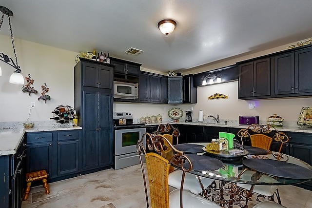 kitchen with appliances with stainless steel finishes, decorative light fixtures, and sink