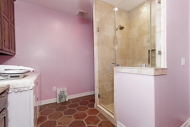 bathroom featuring tile patterned flooring, vanity, and walk in shower