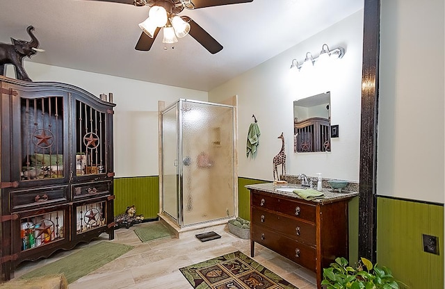 bathroom with ceiling fan, vanity, wood-type flooring, and walk in shower