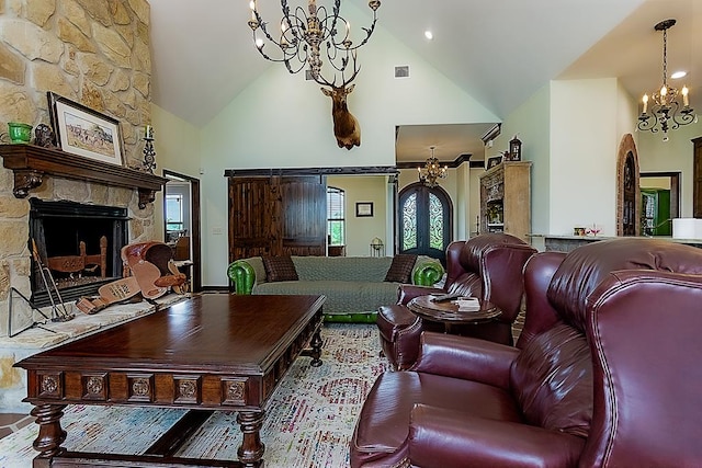 living room featuring an inviting chandelier, high vaulted ceiling, and a stone fireplace