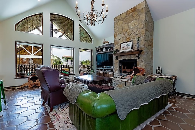 living room with a stone fireplace, high vaulted ceiling, and a notable chandelier