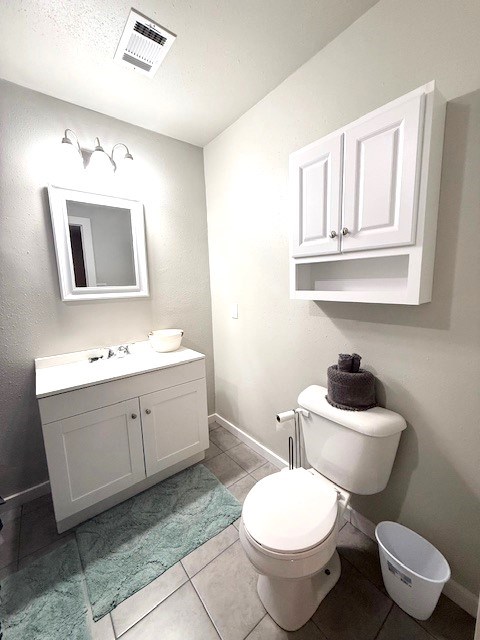 bathroom with vanity, toilet, and tile patterned flooring