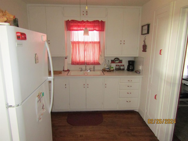 kitchen with white cabinets, sink, white fridge, and dark wood-type flooring