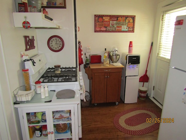 kitchen featuring white appliances, dark hardwood / wood-style floors, and extractor fan