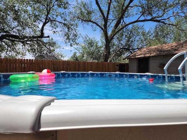 view of pool with a storage shed