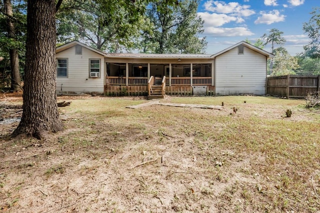 rear view of house featuring a lawn and a sunroom