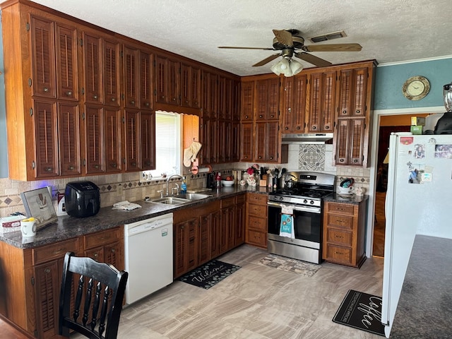 kitchen with ceiling fan, white appliances, under cabinet range hood, a sink, and dark countertops