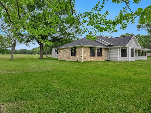 exterior space with a lawn and roof with shingles