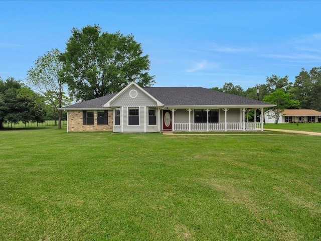 view of front of property with roof with shingles, a porch, and a front lawn