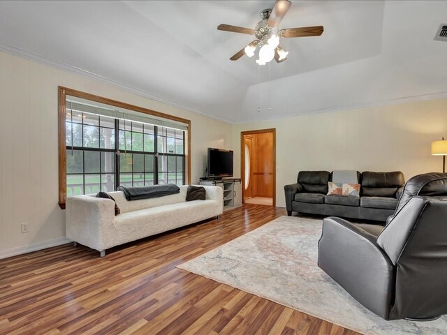 living area featuring visible vents, a ceiling fan, wood finished floors, crown molding, and a raised ceiling
