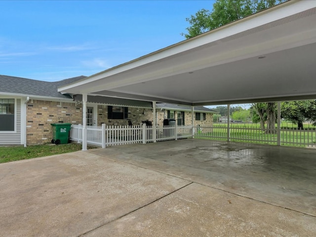 view of patio with concrete driveway, a carport, and fence private yard