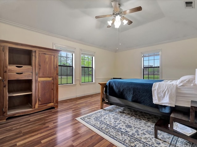 bedroom featuring crown molding, multiple windows, wood finished floors, and visible vents