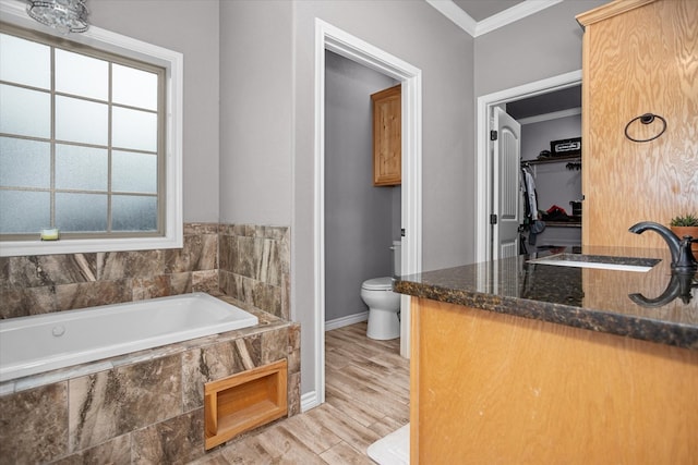 2607 Old Union Rd, Lufkin, TX 75904 - bathroom featuring toilet, a garden tub, healthy amount of natural light, a sink, and ornamental molding