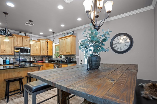 2607 Old Union Rd, Lufkin, TX 75904 - kitchen with stainless steel appliances, ornamental molding, dark countertops, a chandelier, and decorative backsplash