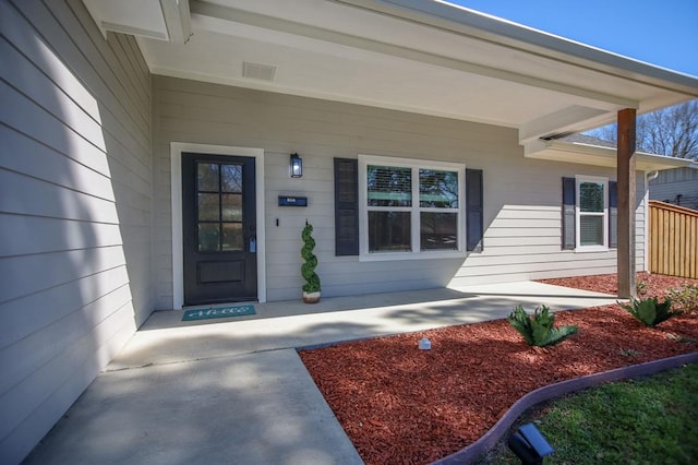 property entrance featuring covered porch and visible vents