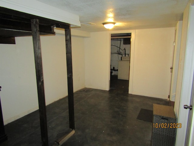 basement with a textured ceiling and washer / dryer