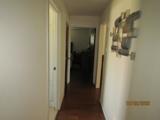 corridor with dark hardwood / wood-style flooring