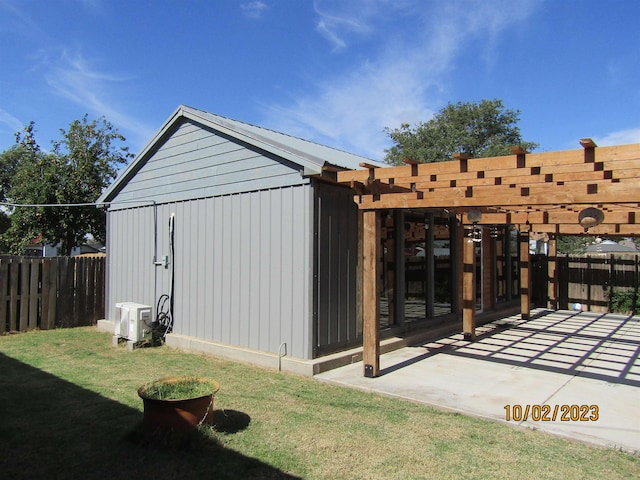 view of outdoor structure with a pergola and a yard