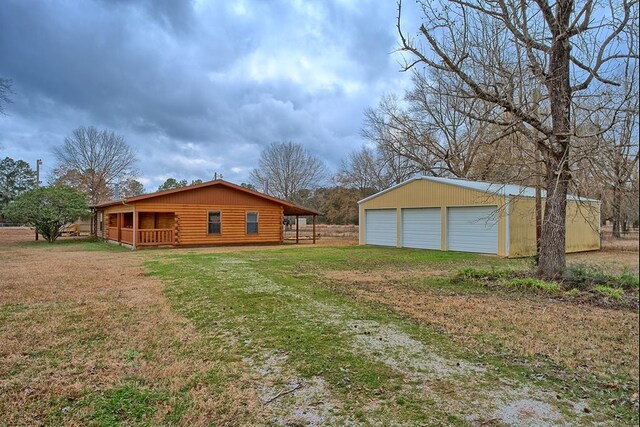 view of side of home featuring a garage, a lawn, and an outdoor structure