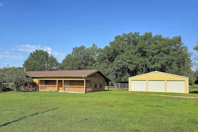 view of front of property featuring covered porch, an outbuilding, a garage, and a front yard