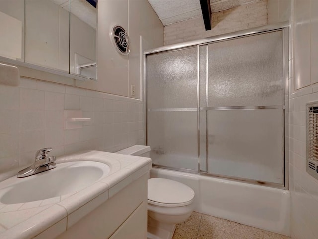 full bathroom with toilet, vanity, tile walls, and combined bath / shower with glass door