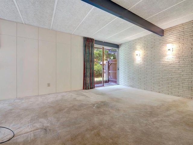 unfurnished room featuring carpet floors and brick wall