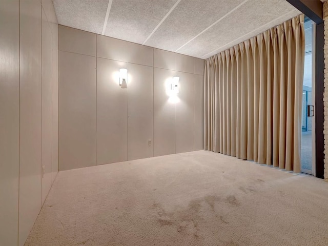 carpeted spare room with a textured ceiling